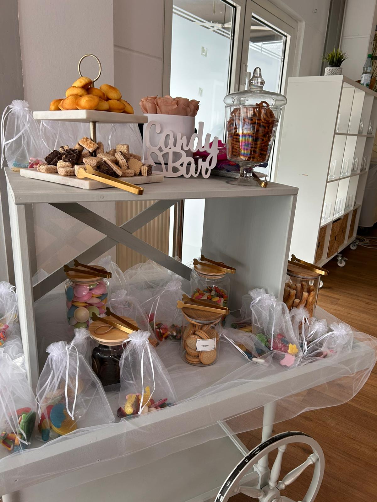 Hübsch verpackte Give-aways in Organza mit Gläsern voller Süßigkeiten